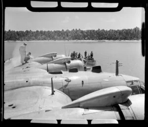 TEAL (Tasman Empire Airways Limited) Flying boat refuelling, Akaiami, Aitutaki, Cook Islands, showing men in boats with barrels of fuel