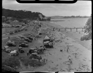 Beach scene at Paihia, Bay of Islands, including bathers, cars and the wharf