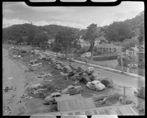 Beach scene at Paihia, Bay of Islands, showing cars, boats and houses