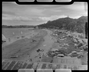 Beach scene at Paihia, Bay of Islands, showing bathers, boats and cars