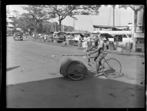 Street scene, man riding a three wheel bicycle with box attached to it, Papeete, Tahiti