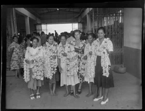 Port building, departure and arrival area, group of women with flower necklaces, Tahiti
