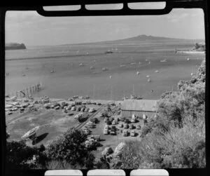Okahu Bay, Auckland, showing yachts at sea and cars on wharf