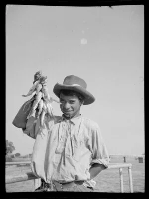 Henry Takimoana in a cowboy hat, showing off his catch of fish, Bay of Islands