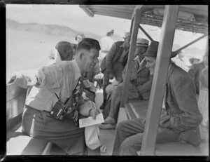 NAC Agent for Kaikohe Mr J Downie (left) talking to an unidentified man during the NAC (New Zealand National Airways Corporation) Bay of Islands scenic flight