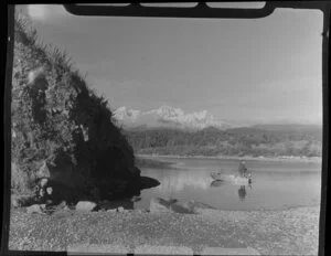 Gillespies Beach lagoon, showing Mount Tasman, Mount Cook and man in dinghy