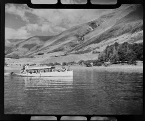 Lake Ohau, Waitaki District, Canterbury Region, showing charter boat with passengers towing a dinghy; Ohau Lodge in the centre