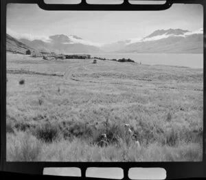 Lake Ohau, Waitaki District, Canterbury Region, showing bus leaving the Ohau Lodge and guests standing in the grass