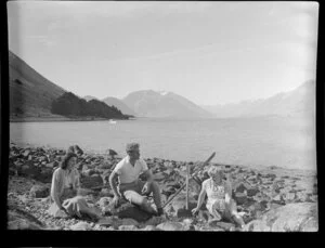 Lake Ohau, Waitaki District, Canterbury Region, showing unidentified people sitting on rocks by the lake