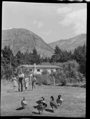 Peter Bayne and children in front of the Huxley Gorge Station homestead, near Lake Ohau, Waitaki District, Canterbury Region, showing Canadian geese in the foreground