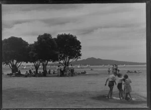 Mission Bay, Auckland, showing people on the beach watching yachting regatta and Rangitoto Island in the background
