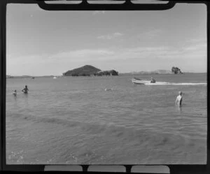 Paihia, Northland, showing bathers and man passing in a boat