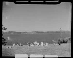 Waitangi Treaty Grounds scene, including people relaxing and enjoying the view of Russell, Bay of Islands