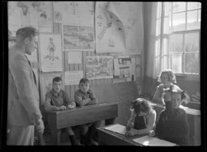 Children at Weheka School listen to their teacher while sitting at desks, West Coast Region