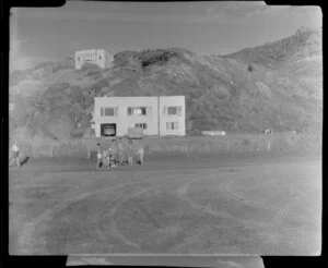 Piha, Auckland, showing people and houses in the background