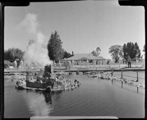 Government Gardens, Rotorua, showing steaming geothermal man-made fountain in pool with lawn bowls beyond