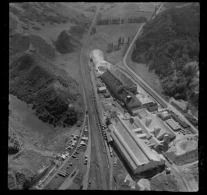 Wanganui, closeup view of Kempthorne Prosser Chemical Works with Brunswick Road and railway yard with stacked timber