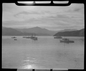 Akaroa, Banks Peninsula, showing boats in the harbour with sun shining on water