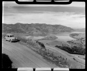 Akaroa, Banks Peninsula, showing hills and car parked by side of the road