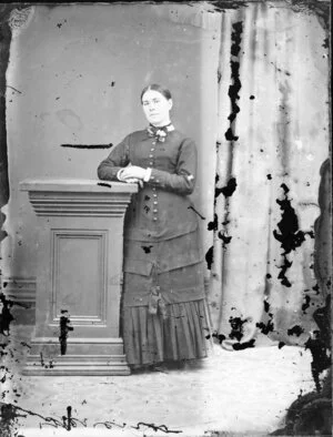 Unidentified woman,wearing a dress with a fitted skirt, with layers and pleating