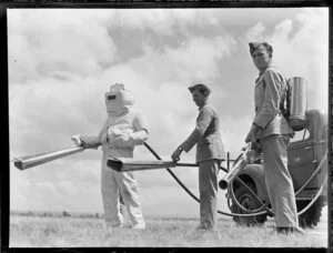 Central Flying School, Tauranga, men with flame throwers (?), one suited