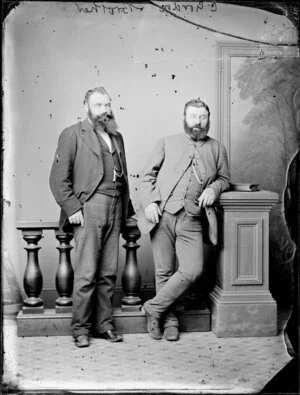 Full length portrait of Mr C Gordon and his brother; both wear suits