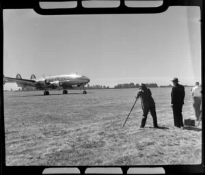 Unknown photographer taking photo of aircraft standing on airfield, dedication of Harewood Airport, Christchurch