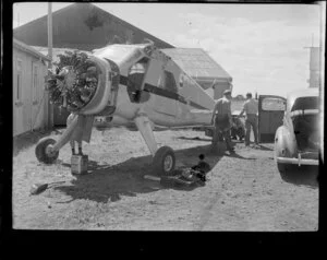 Unidentified group of men working on a De Havilland Beaver aircraft at Mangere, Auckland