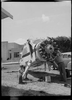 Unidentified men working on a De Havilland aircraft at Mangere, Auckland