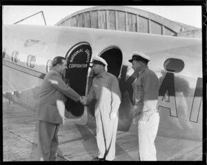 Pilots being greeted in front of New Zealand National Airways Corporation (N A C) Lodestar ZK-ANA aircraft named Kawatere, location unidentified