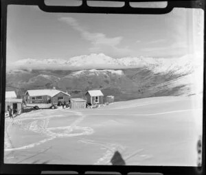 Skiing on Coronet Peak, Otago, showing chalet and view over neighbouring mountains