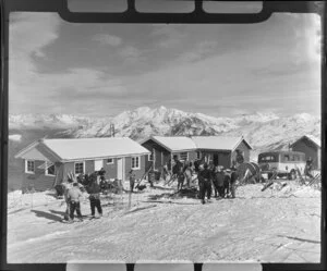Groups of skiers outside the Happy Valley Chalet, skiing on Coronet Peak, Otago