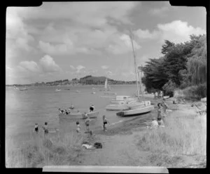 Beach at Onehunga, Auckland with children playing in a rowing boat and in the water
