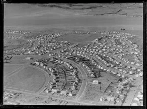 View of new housing development Glen Innes, Auckland City, showing Pilkington Road, Hobson Drive to Dunkirk Road with school by tidal estuary, looking to Half Moon Bay with farmland beyond