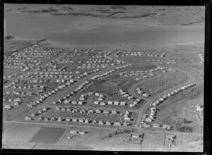 View of new housing development Glen Innes, Auckland City, with Pilkington Road, Tripoli Road and Anderson Avenue, looking towards Point England Reserve, tidal estuary and Half Moon Bay with farmland beyond