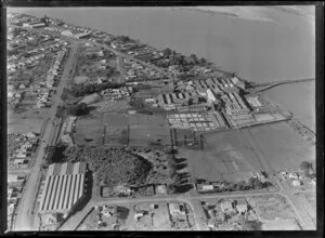 View over the New Zealand Refrigerating Company, Imlay Freezing Works Imlay Place, Wanganui, with stock pens and yards, showing Heads Road, Balgownie Avenue and Beach Road surrounded by residential housing, located beside the Wanganui River with wharf for loading ships