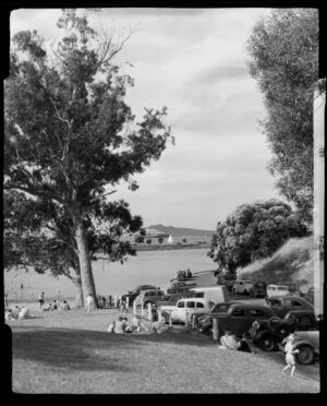 Judges Bay, Parnell, Auckland, showing cars parked and people on grass area near beach