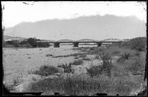 River, showing a steel bridge with multiple arches, and houses on far side of riverbank, probably Hutt Valley