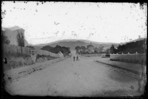 Unidentified street in Thorndon, Wellington, including two boys with bicycle, Oriental Bay in background
