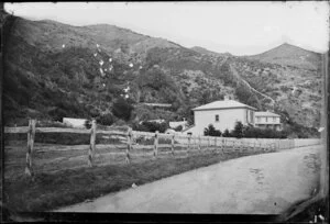 Houses and fenced garden on a unidentified street at the base of a hill [Oriental Bay, Wellington?]