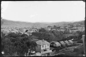 Overlooking Thorndon, towards Wellington Harbour and Oriental Bay, showing the armed constabulary cottages on corner of Grant Road and Park Street, and buildings on Tinakori Road