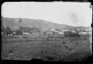 [Thorndon?] Wellington, showing a steam locomotive engine travelling on a railway line that is in front of a row of houses