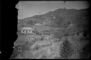 View across fenced domestic gardens towards hills, showing several houses, probably Wellington