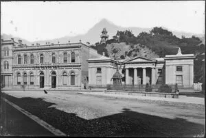 Buildings at the intersection of Featherston Street and Lambton Quay, Wellington, including The Supreme Court, and tower [observatory?] on hill behind