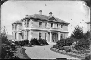 A two-storied house with a gravel driveway and landscaped garden, probably Wellington
