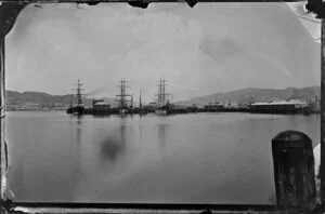 View looking south across Lambton Harbour, Wellington, showing ships docked at wharves and Harbour Board sheds