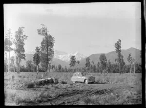 Fox Glacier, West Coast Region, showing Vanguard and Mount Cook; in the foreground a car and logs