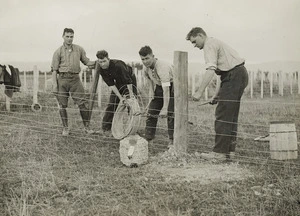 Creator unknown : Men constructing a wire fence