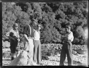 Amphibian Airways, George Sound, Fiorland, showing hunters on rocky shore with potatoe bag