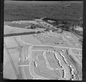 Murupara, Whakatane District, Bay of Plenty, showing newly developed housing subdivision and timber workers cabins beside State Highway 38 with pine forest beyond